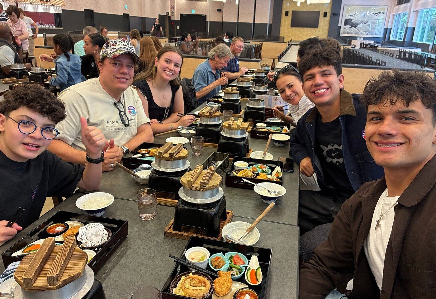 Travelers at a long table for the Mount Fuji tour lunch, with hot pots and set trays